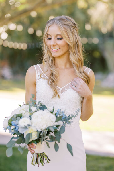 Individual portrait of just the bride looking down at her bouquet at her gorgeous southern california wedding