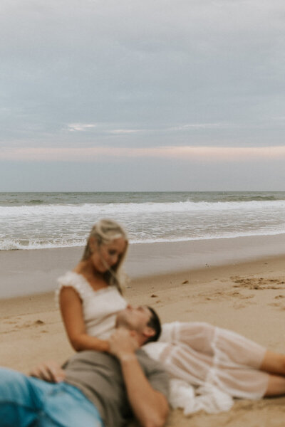 bride and groom embracing on beach engagement session