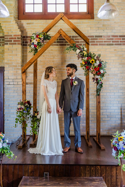 Bride and groom holding hands at a church ceremony at Clayburn Church.