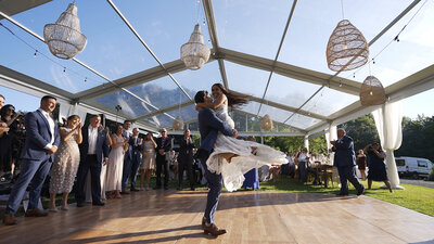 Groom picks up and spins bride during first dance