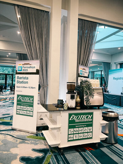 Quigley Coffee Co barista station at a corporate event with espresso machine and branded setup, providing coffee catering for business conferences.