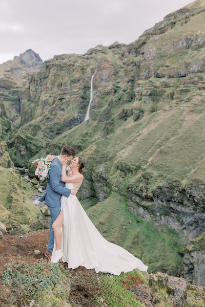 during an elopement in Iceland, this couple kissed on the side of a lush green canyon in the South West of Iceland.