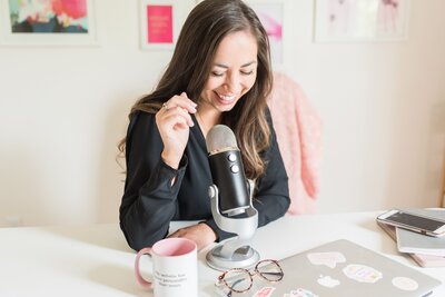 Elizabeth McCravy smiling at her podcast microphone for her branding photos with Mandy Liz