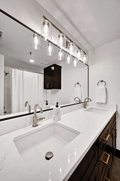 Master bathroom vanity with dual sinks in this one-bedroom, one-bathroom rental condo in the historic Behrens building just blocks from the Magnolia Silos and Baylor University in downtown Waco, TX.