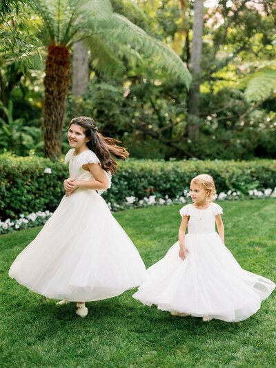 Flower girls twirling in dresses during a wedding at the Beverly Hills Hotel.