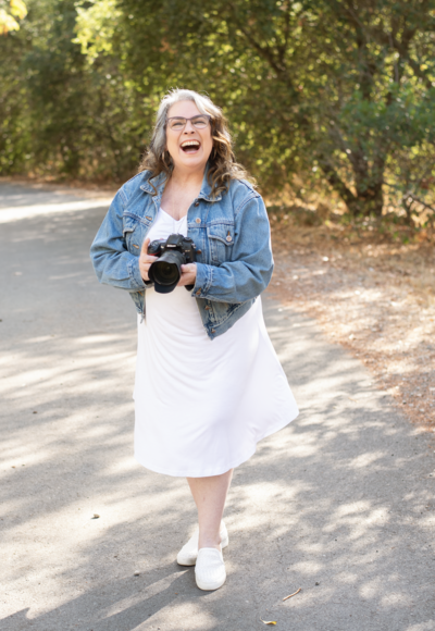 Photographer outside holding camera and laughing