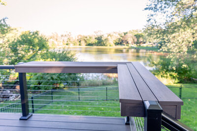 An aluminum deck railing with an extra-wide drink rail on top, functioning as an additional bar space during gatherings. 