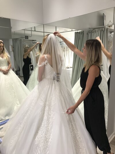 bridal stylist placing veil on bride