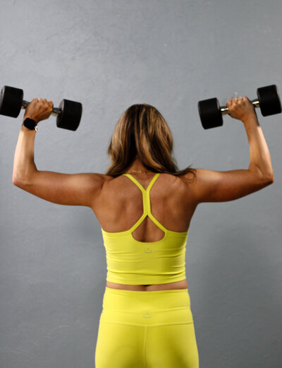 Client lifting dumbbells during Power Circuit class at TruFit Pilates