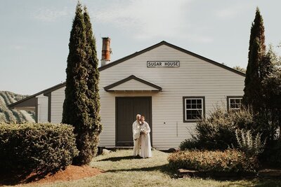 Brides standing together in front of Sugar House, Berkshire Farm Wedding