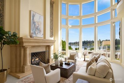 lake washington waterfront aerial view with luxury home  lit at night  showing docks and boats in lake along with green lawn and landscaping