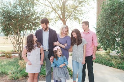 Photograph of family by Macon GA photographer Ann Steward. Family with four children laughing and smiling during photo session with Ann Steward Photography.