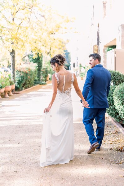 Tlaquepaque Weddings Bride and Groom walking while Bride holds dress