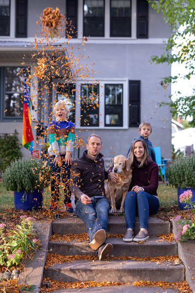 Fall family throwing leaves in air for Twin Cities Family Photographer