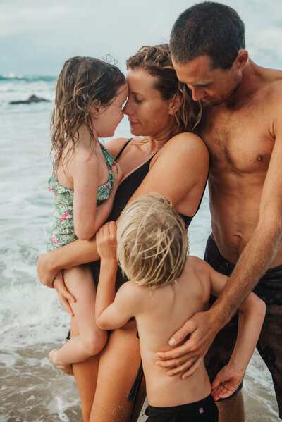 family embracing closely on the beach