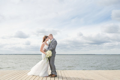 Bride and groom take photo on fishing dock at Lavallette Bay Barnegat Bay.