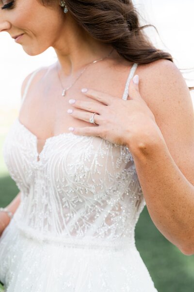 Close up of bride smiling showing her ring.