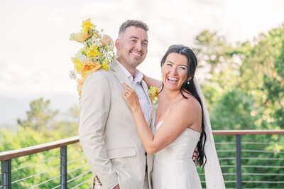 A smiling couple dancing on a wrap around deck in the Smoky Mountains during their summer destination wedding by JoLynn Photography