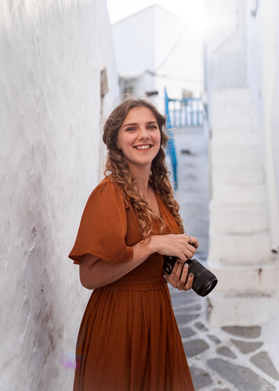 Wedding photographer in greece holds camera for headshots