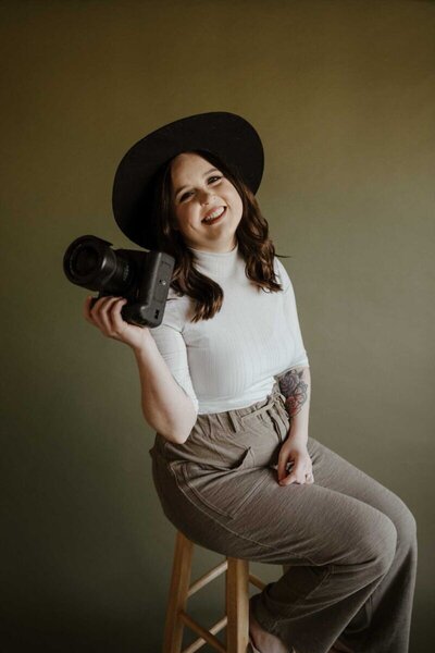Girl holding camera in studio