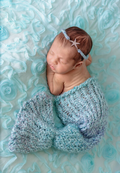 Newborn Photographer, a baby wears a knit mermaid costume
