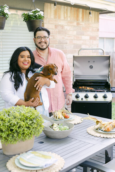 couple and dog grilling on patio