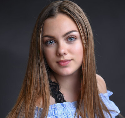 Young actress headshot wearing blue top