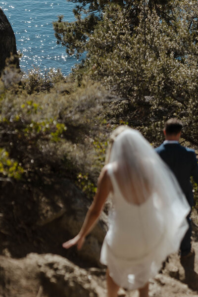 elopement couple hiking to the water in lake tahoe