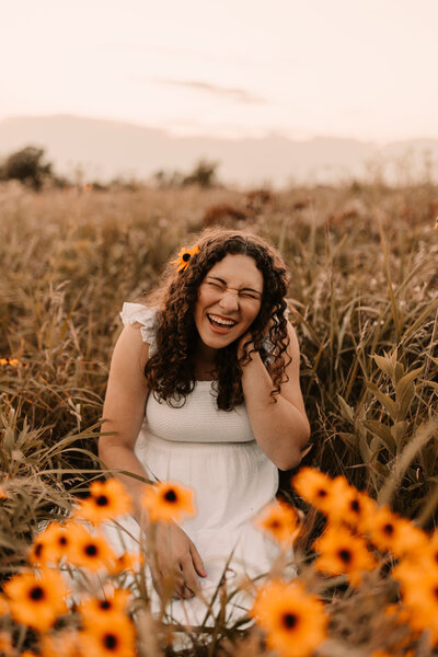 senior photos in a field of yellow flowers
