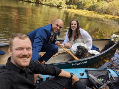 Elopement photographer takes a selfie with a couple in a canoe