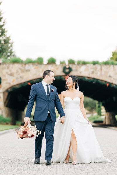 A wedding couple at Bella Collina in front of the bridge walking by Florida wedding photographer Angelika Krug Photo & Film