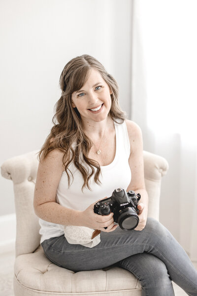 Jessica Lee sitting in chair holding camera in lap