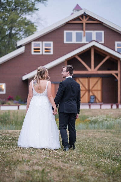 bride and groom walking in the field of barnwood events, a wedding venue in madison, winconsin.
