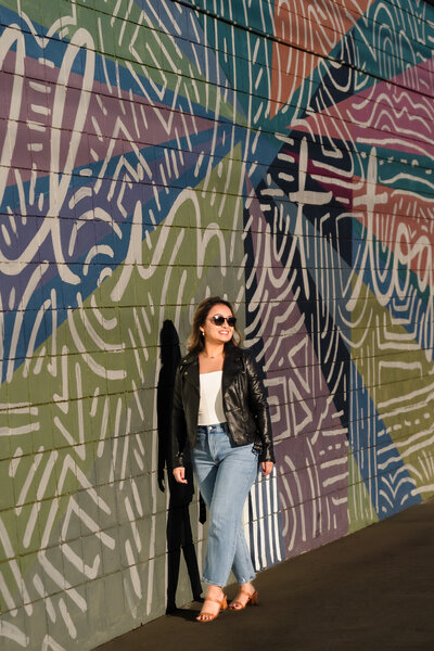 brand photo of a coach walking close to a colorful mural