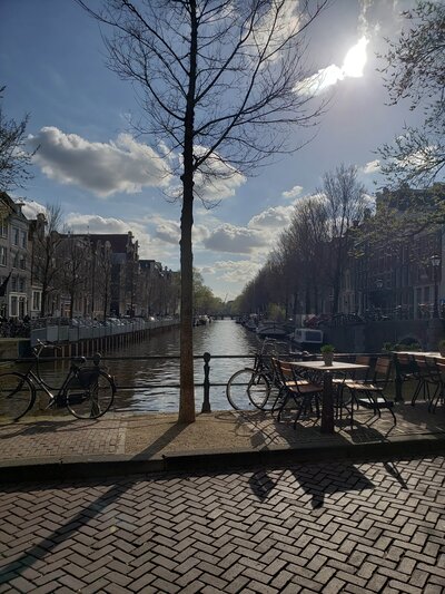 Peaceful canal view with brick walkway and bare trees under sunlight – photographed by wedding photographer Niko Coric – Lumen Clarity Media
