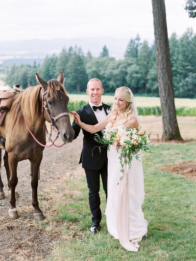 film portrait of a bride and groom with a horse