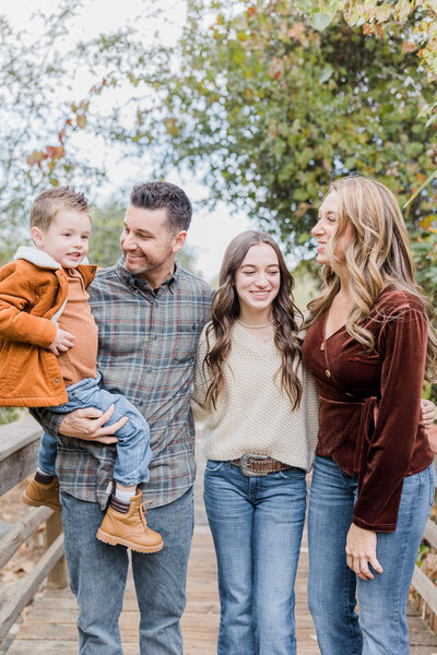 Beautiful family laughing together in Sacramento, CA park during their family photography by Caroline Bendel