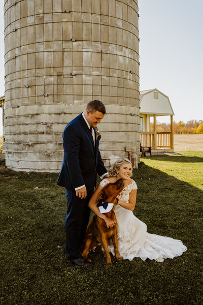 married couple cuddling and kissing their dog in central Minnesota