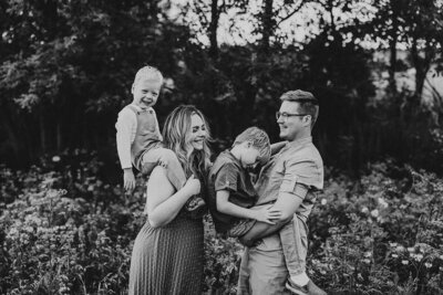 Black and white image of photographer Kara Krause with her family (husband and 2 sons).