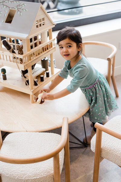 A young patient plays with wooden toys in the waiting area of Little Chompers Pediatric Dentistry, located in one of the most liberal Chicago suburbs, Andersonville.