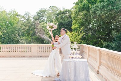 Bride and groom opening Champagne bottle on their wedding day