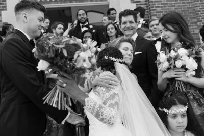 mother of the groom hugs bride after ceremony in a crowd
