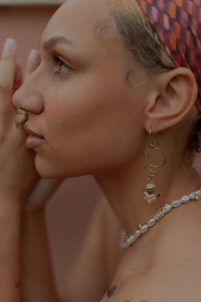 Woman of color models a small business jewelry brand