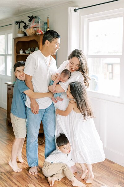 Katelyn and Dan Ng stand with their children in their home in Indianapolis.