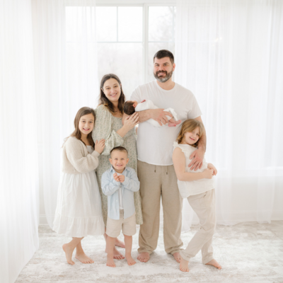 large family smiles at camera during boston newborn photoshoot