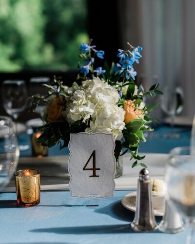 table setting with flowers and a card that says four on it