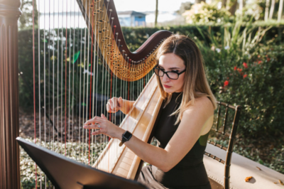 woman  with glasses playing  a harp
