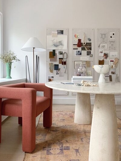 Interior design studio with armchair, styling samples, and layout planning board.