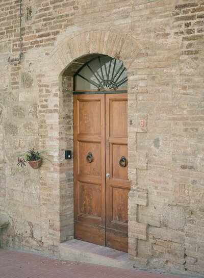 brown wooden door and brown bricks in tuscany italy travel photo
