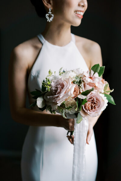beautiful asian bride holds soft romanic wedding bouquet